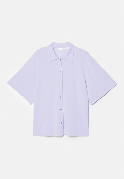 Short-sleeve lavender shirt with a pointed collar, made of smooth fabric, featuring a button-up front and a boxy silhouette.