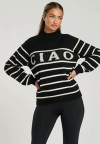 Schwarz-weiß gestreifter Pullover mit hohem Kragen, der das Wort "CIAO" in fetten Buchstaben auf der Brust trägt, weiche Textur, lässige Passform.