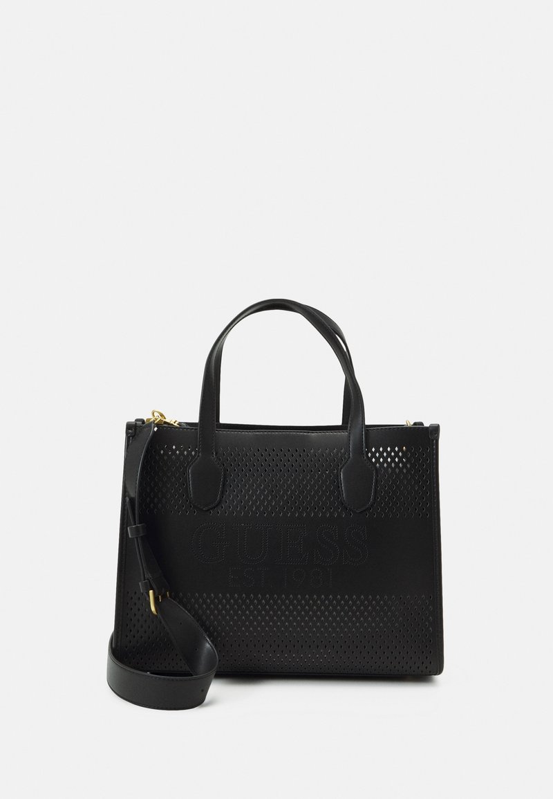 Sac à main Guess en cuir noir avec design perforé, deux poignées, bandoulière amovible et logo embossé à l'avant.