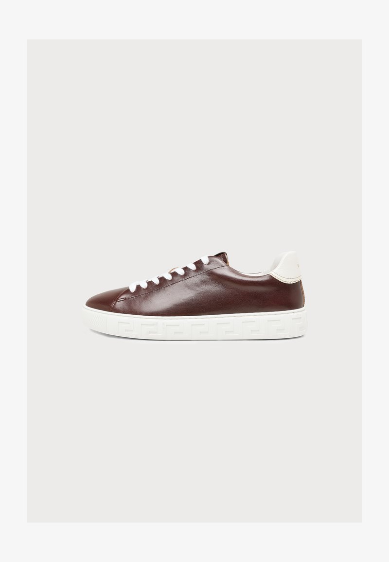 Καφέ δερμάτινο sneaker χαμηλού ύψους με λευκά κορδόνια και παχιά λευκή σόλα με διακριτικό γεωμετρικό σχέδιο.