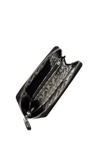 Portefeuille noir zippé avec un extérieur en cuir lisse, plusieurs compartiments et un intérieur en tissu à motifs avec un design manuscrit.