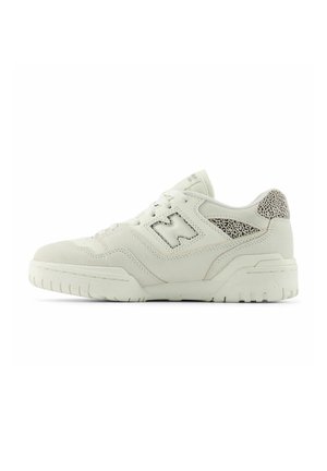 Zapatilla baja de ante blanco con acentos texturizados. Diseño de corte bajo, que presenta un logo cosido y una suela de goma con un patrón de relieve distintivo.
