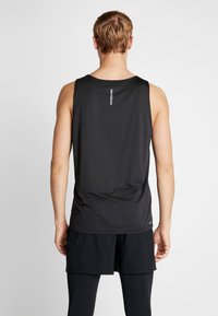 Czarny sportowy top na ramiączkach wykonany z lekkiego materiału. Posiada okrągły dekolt, bez rękawów oraz małe logo na plecach.