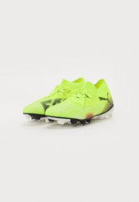 Bottes de football d'un jaune vif avec un motif texturé, des accents noirs et des crampons blancs. Elles présentent un collier tricoté ajusté et un design à lacets.