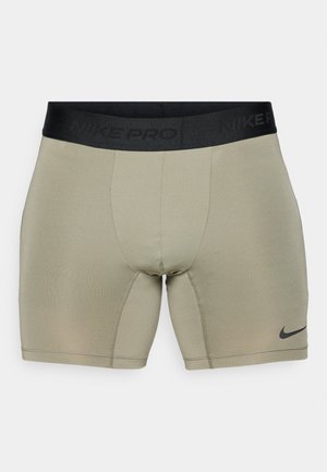 Herren Nike Pro Kompressionsshorts in hellolivgrün, mit einem schwarzen Bund mit geprägt Branding und einem glatten, dehnbaren Stoff.