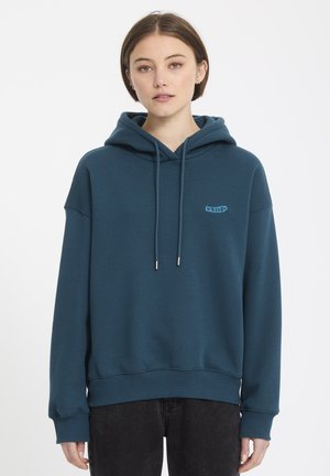 Teal hoodie van zachte stof, met een grote capuchon, koordjes met metalen uiteinden en een klein logo geborduurd op de voorkant.