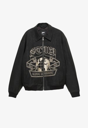 Giacca in pelle nera con colletto appuntito, chiusura frontale con zip, tasche laterali e stampa grafica dorata con un globo e dettagli testuali.