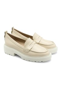 Beige leren instappers met een gestructureerde afwerking, voorzien van een gestikte banddetail en een dikke witte rubberen zool. Rond neus en ritssluiting bij de hiel.