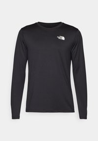 Langærmet sort performance T-shirt lavet af letvægtsstof, med et hvidt logo på den øverste venstre brystkasse. Glat tekstur.