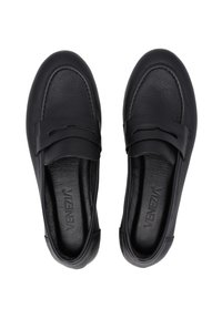 Schwarze Leder Slipper mit flacher Sohle, die einen dekorativen Riemen über dem Spann und eine glatte, strukturierte Oberfläche aufweisen.