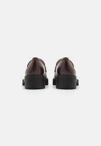Brown leather shoes with a glossy finish, featuring a rounded toe and black chunky heel. No visible hardware or patterns.