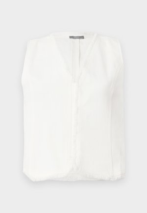 Hvit ermela bluse med V-hals, med frynsekant langs kantene og en sentral glidelås for lukking. Glatt, lett stoff.
