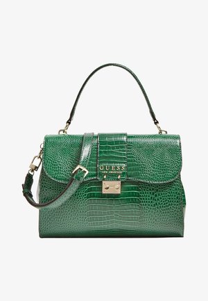 Bolso verde con textura de cocodrilo, asa superior, correa de hombro ajustable, cierre dorado y logotipo GUESS Los Ángeles en la solapa frontal.