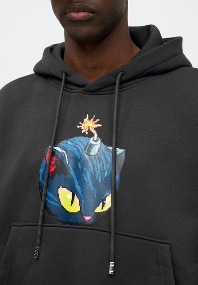 Felpa con cappuccio di colore grigio scuro, caratterizzata da un design di un gatto pixelato blu con occhi gialli vivaci e un accento a forma di bomba sulla testa.
