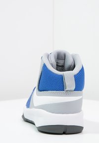 Niebiesko-szare buty sportowe z teksturowaną siateczką na górze, wyściełanym kołnierzem i gumową podeszwą. Posiadają pętelkę z tyłu.