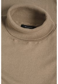 Pulover bej cu gât înalt, realizat dintr-un material tricotat moale. Are un guler rib elastit și o textură subtilă, având o etichetă pe care scrie "Matinique Europe."