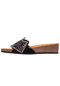 Sandal in suede nero con tacco a zeppa in sughero, caratterizzato da un'ampia decorazione a fiocco con borchie argentate e una soletta liscia.