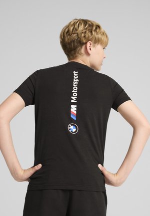 Fekete pamut póló, függőleges "M Motorsport" logóval és BMW kerek emblémával a hátsó részén, rövid ujjú, kerek nyakkivágású.