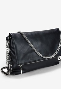 Clutch in pelle nera con un flap pieghevole, caratterizzato da dettagli con catena argentata e una tasca con zip nella parte frontale per un tocco in più.