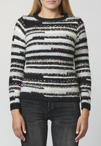 Knit sweater featuring black, white, and multicolored striped patterns. Rounded neckline and ribbed cuffs; soft texture with a cozy appearance.