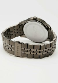 Silberne Edelstahl-Uhr mit einem Gliederarmband, einem runden Gehäuse, einer Krone und einemgravierten Markenlogo auf der Schließe.