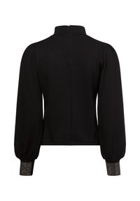 Zwarte blouse met pofmouwen, een hoge kraag en een ritssluiting achter. De boorden zijn versierd met een glanzende textuuraccent. Glad stoffen afwerking.