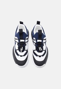 Αθλητικά παπούτσια με επάνω μέρος από δίχτυ σε ναυτικό μπλε και λευκό, μαύρη σόλα από καουτσούκ, ελαστικά κορδόνια και λουράκι στην γλώσσα για εύκολη φορεσιά.