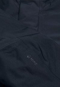 Giacca impermeabile di un elegante blu navy, caratterizzata da un design raffinato, texture del tessuto e logo "HIPE" in rilievo sulla manica.
