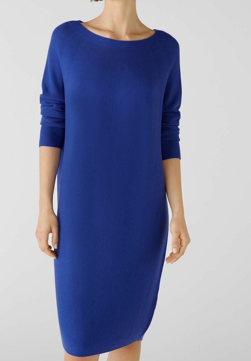 Abito blu lavorato a maglia con scollo rotondo, maniche a tre quarti e una vestibilità rilassata, caratterizzato da una texture liscia e un design minimal.
