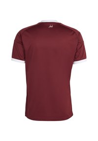 Maroon sportska majica s bijelim detaljima na ovratniku i rukavima. Ova majica ima teksturiranu tkaninu i arapski tekst na gornjem dijelu leđa.