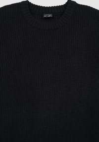 Czarny dziergany sweter o prążkowanej fakturze, z klasycznym okrągłym dekoltem i metką wszytą na środku.