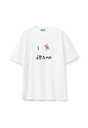Biała koszulka z krótkim rękawem z czarnym, ręcznie napisanym napisem „I dRAMA” i czerwonym przekreślonym sercem nad słowem.