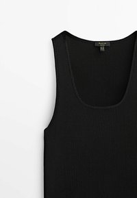Sort ribbet tanktop med en scoop-neckline. Tætsiddende design med sømløse kanter. Blød tekstur, let materiale. Ingen synlige mønstre eller detaljer.
