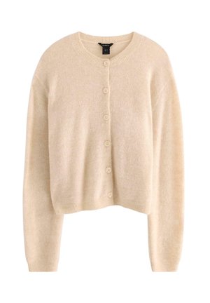 Beige kort cardigan tillverkad av ett mjukt tyg, med rund hals, långa ärmar och sex matchande knappar framtill.