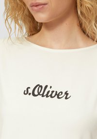 Weißes, kurzärmliges Oberteil mit einem schwarzen Schriftlogo "s.Oliver" auf der Vorderseite, aus weichem Material mit glatter Textur hergestellt.