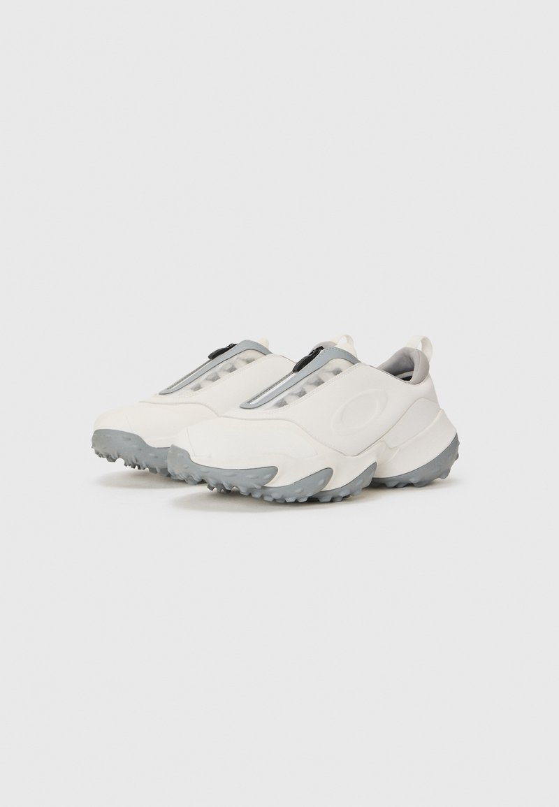 White athletic shoes with a sleek design, featuring a grey panel and textured sole for grip. Zipper closure and soft interior lining.