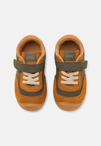 Sneaker marroni e verdi con tomaia in suede, fodera in rete di tessuto, lacci elastici, cinturino in Velcro e suola in gomma.