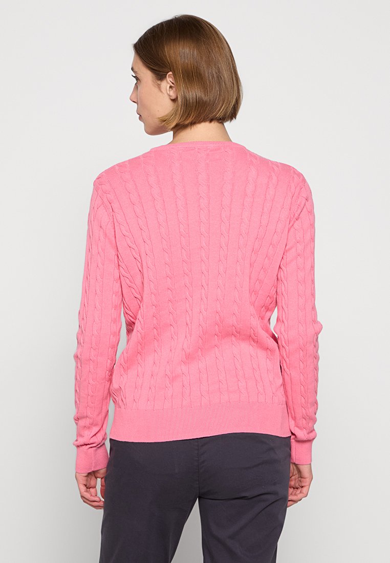 Rosa kabelgestrickter Pullover mit Rippendesign, langen Ärmeln und rundem Halsausschnitt, tailliert an der Taille und den Bündchen.