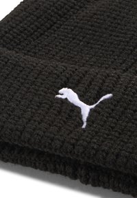 Black knitted beanie featuring a textured design, with a white embroidered Puma logo on the front. Soft, cozy material.
