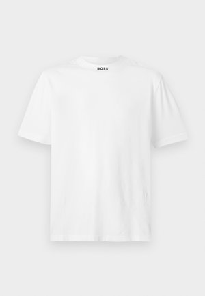 Vitt kortärmat T-shirt i bomull. Har rundad halsringning och en svart tryckt logotyp på kragen. Slät textur, enkel design.