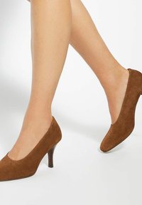 Brown suede high-heeled pumps with a rounded toe and a slim, textured heel. Smooth surface with a matte finish.