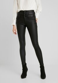 Zwarte faux leren skinny jeans met een hoge taille, voorzien van vijf knoopsluitingen, zijzakken en een gladde, glanzende textuur.