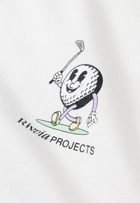 Personaggio dei cartoni animati che assomiglia a una pallina da golf con un volto sorridente, che tiene una mazza da golf. Il design presenta colori nero, bianco e viola, su tessuto bianco.