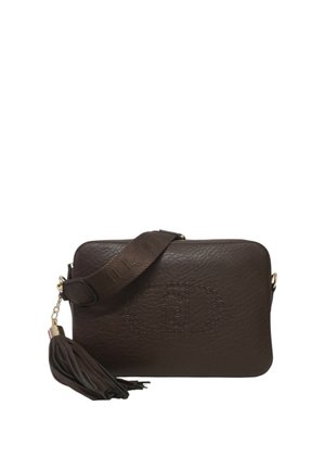 Sac bandoulière en cuir marron avec logo embossé, surface texturée, fermeture éclair et un accent en pompon amovible sur la sangle.
