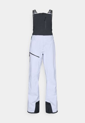 Wasserdichte Skihosen in Weiß, mit einem schwarzen oberen Bereich, verstellbaren Trägern, seitlichen Reißverschlusstaschen und verstärkten schwarzen Bündchen am Saum.