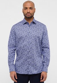 Camicia a maniche lunghe blu con motivo floreale in varie tonalità di blu, con chiusura a bottoni sul fronte e collettino standard.