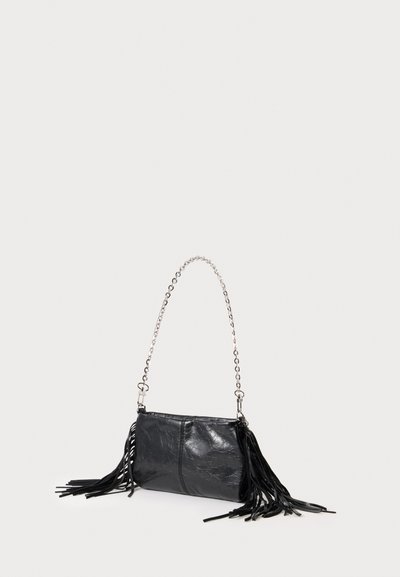 Pochette en cuir noir avec bandoulière chaîne argentée et longues franges en cuir de chaque côté, présentée sur un fond clair uni.