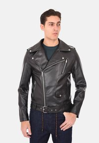 Giacca da motociclista nera in pelle con rever a scollatura, zip asimmetrica e tasca sul petto con zip. Texture liscia con vita regolabile.