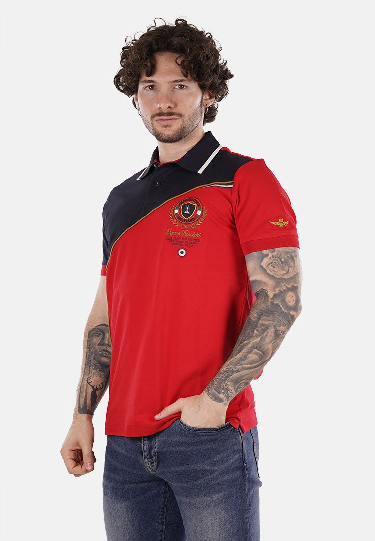 Polo rosso con dettagli blu navy, colletto bianco e logo ricamato. Maniche corte e vestibilità slim. Presenta un design diagonale.