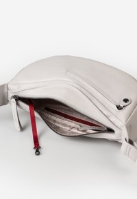Borsa in pelle grigia chiara con chiusura a zip. L'interno presenta una tasca con zip rossa e una fodera a fantasia. Texture liscia e design minimalista.